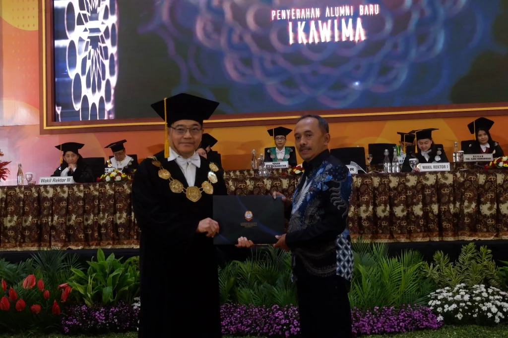 Penyerahan anggota alumni baru UKWMS oleh Rektor (Kiri) kepada Ketua Ikatan Alumni Marselinus Jeramun S.E